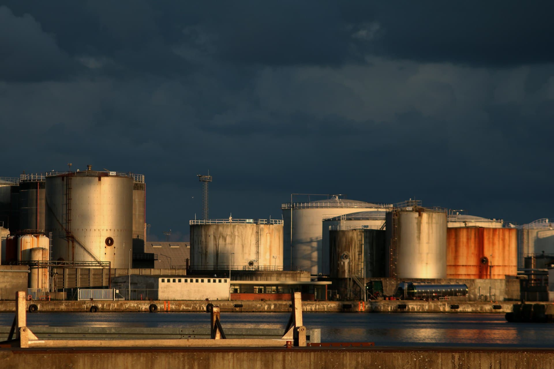 Fuel storage tanks under a dark evening sky